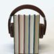 Headphones around a stack of books.